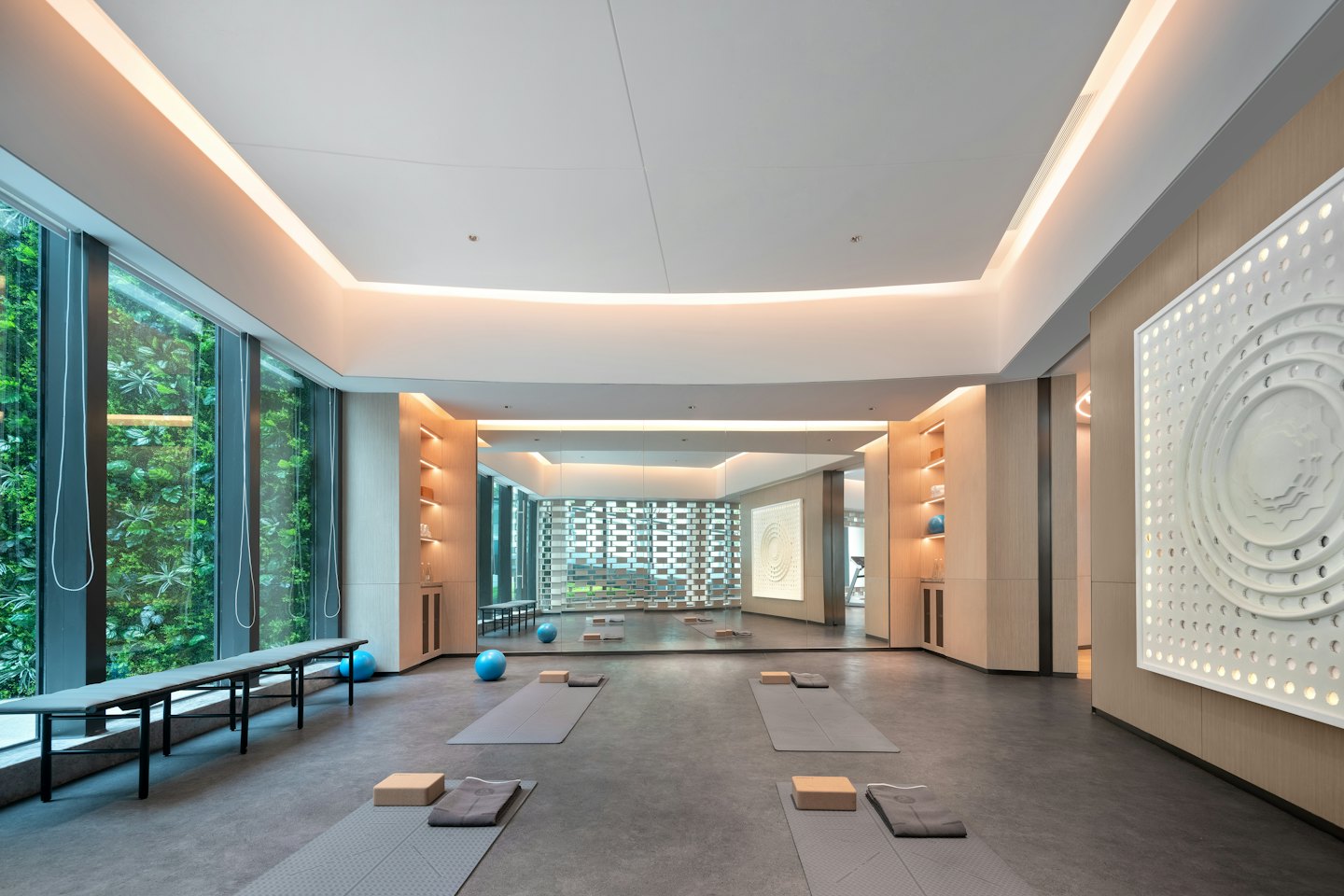 Grey yoga mats and blocks arranged in a spacious, sunlit studio.